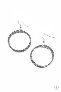 Delicately hammered in light-catching detail, an asymmetrical silver hoop swings from the ear for an artisan inspired look. Earring attaches to a standard fishhook fitting.