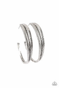 Featuring lifelike textures, a glistening silver feather hoop curls around the ear for a seasonal look. Earring attaches to a standard post fitting. Hoop measures 2" in diameter.