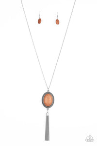 An earthy brown stone is pressed into the center of an oval silver frame dotted in studded textures. Infused with a whimsical silver tassel, the seasonal pendant swings from the bottom of a lengthened silver chain for a seasonal look. Features an adjustable clasp closure.