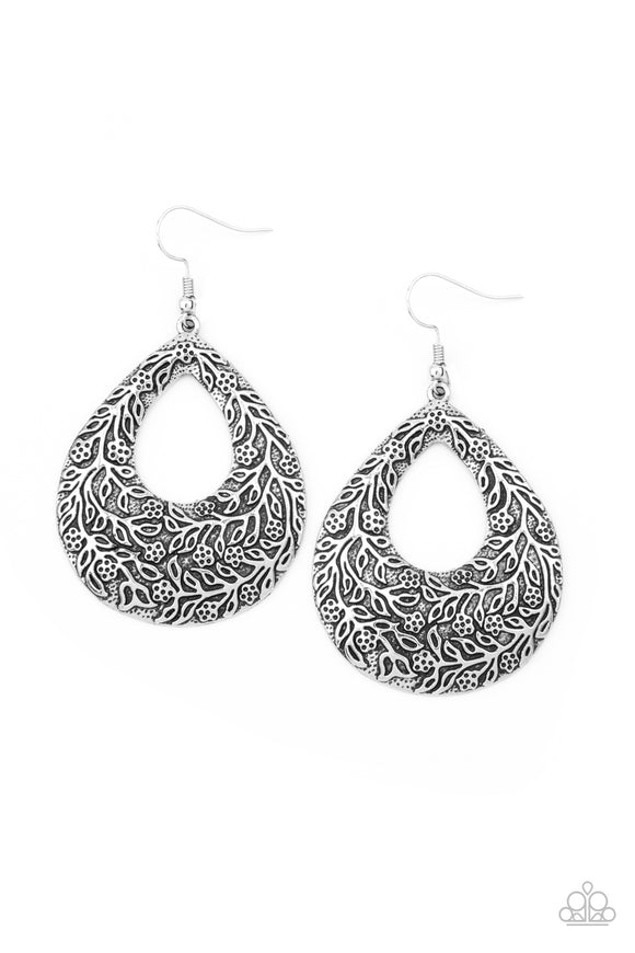 Antiqued floral filigree is embossed across the front of an oversized silver teardrop, creating a whimsical frame. Earring attaches to a standard fishhook fitting.