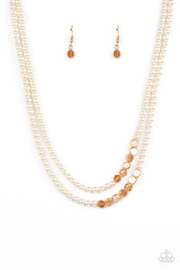 A posh collection of pearly white beads, accented with sections of flat, faceted shimmery transparent gold beads, is threaded along invisible wires, creating sophisticated layers that fall below the collar. Features an adjustable clasp closure.  Sold as one individual necklace. Includes one pair of matching earrings.