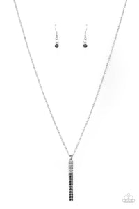 A sparkly collection of white, smoky, and black rhinestones are encrusted along a silver pendulum that swings along the bottom of a silver chain, creating a glittery ombre effect. Features an adjustable clasp closur