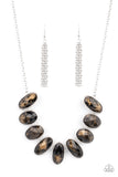 Generous glossy black gems, dusted in shimmery gold, lay in silver oval frames and link across the collar creating a glimmering statement. Features an adjustable clasp closure.  Sold as one individual necklace. Includes one pair of matching ea