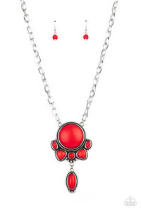 A large red stone encased in a studded silver frame swings dramatically from a heavy silver chain with oversized links. A collection of red stones wraps around the bottom of the large pendant, with an elongated oval stone swaying below them. Features an adjustable clasp closure.  Sold as one individual necklace. Includes one pair of matching earrings.