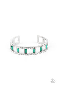 Bands of glittery white rhinestones overlaid on silver frames create an airy channel-like framework. Elegant baguette style cut green gems, connected to the glittery framework, circle around the wrist for a romantically decadent cuff bracelet.