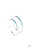 The front half of a dainty silver hoop is encrusted in an ombre of blue rhinestones, creating a sparkly spectrum of color. Earring attaches to a standard post fitting. Hoop measures approximately 1 1/2" in diameter.