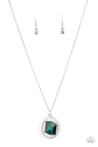 A raw cut green gem asymmetrically adorns the center of a warped white rhinestone oval frame, creating an extra sparkly pendant at the bottom of a classic silver chain. Features an adjustable clasp closure.