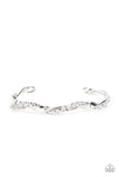 A glittery strand of glassy white rhinestones twists with a shiny silver bar around the wrist, creating a dainty cuff