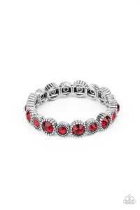 Featuring mismatched silver studded fittings, an oversized collection of sparkly red rhinestones are threaded along a stretchy band around the wrist for a fiery pop of color.