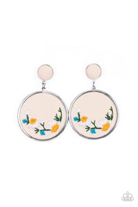 A small leather disc, encased in a simple silver frame, anchors a larger leather circle that is adorned with fanciful embroidered flowers creating a whimsical lure. Earring attaches to a standard post fitting.