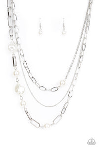 Bubbly round and imperfectly faceted white pearls haphazardly adorn an assortment of mismatched chunky and dainty silver chains, resulting in an edgy refinement below the collar. Features an adjustable clasp clos