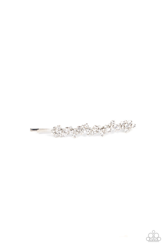 A starry collection of glassy white rhinestones delicately cluster along the front of a classic silver bobby pin, invoking an effervescent elegance.