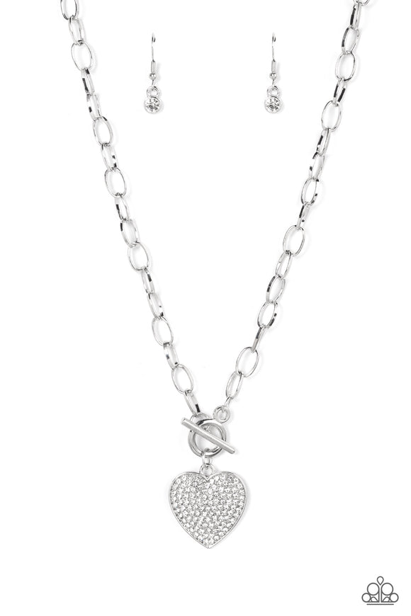 A white rhinestone dotted silver heart frame sparkles from a toggle closure at the center of an oval silver linked chain for a flirtatious fashion. Features a togg