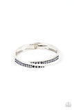 Dotted in rows of glitzy blue rhinestones, two silver bars delicately curl and overlap across the center of the wrist. Featuring angled edges, the overlapping bars connect to hinged closures for a versatile bangle-like finish. Features a hinged closure.