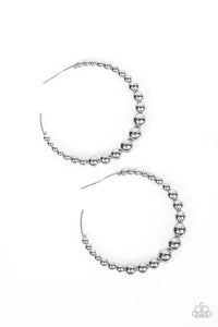 Gradually increasing in size, shiny silver beads are threaded along an oversized silver hoop for a gritty and glamorous effect. Earring attaches to a standard post fitting. Hoop measures approximately 2 1/2" in diameter.