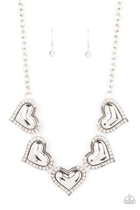 Bordered in glassy white rhinestones, an oversized collection of beveled silver heart frames delicately links below the collar for a dramatically romantic look. Features an adjustable clasp closure.