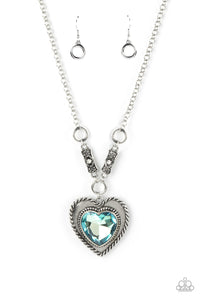 Bordered in spun silver ribbons, an oversized blue heart gem is pressed into a silver heart frame below the collar. The flirtatious pendant attaches to silver rings and decorative silver frames dotted in white rhinestones, resulting in a dash of vintage inspired romance. Features an adjustable clasp closure.