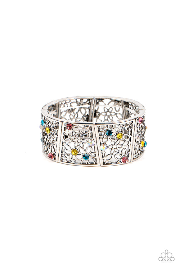 Sporadically dotted with multicolored and iridescent rhinestones, an airy daisy pattern blooms inside trapezoidal silver frames that are threaded along stretchy bands around the wrist for a seasonal statement. Due to its prismatic palette, color may v