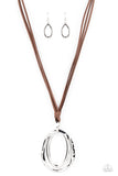 Long strips of brown leather knot around a silver link where a mismatched pair of smooth and hammered silver ovals swing from the bottom, resulting in a rustic pendant. Features an adjustable clasp