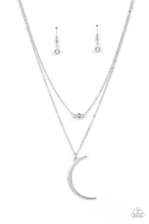 Two dainty silver chains delicately layer below the collar. A metallic crystal-like bead sparkles at the center of the uppermost chain while a silver half moon pendant swings from the bottom of the display for a mystical finish. Features an adjustable clasp closure.