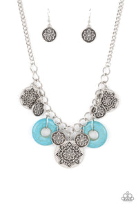 A collection of silver discs, embellished with intricate mandala-like designs, dances along a thick silver chain, with a pair of polished turquoise stone rings adding a pop of color to the rustic design. Features an adjustable clasp closure.