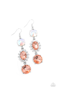 A trio of colorfully iridescent and brilliantly sparkling peach gems are linked together as they fall glamorously from the ear. A round-cut gem with an exaggerated faceted surface anchors the cascade, followed by an oval-cut peach rhinestone bordered in classic white rhinestones. Another round-cut gem — this one in a peach hue — finishes off the design in a sparkling finish. Earring attaches to a standard fishhook fitting. Due to its prismatic palette, color may vary.