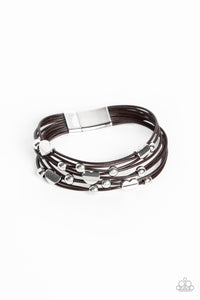 Row after row of dark brown cords layer around the wrist. Varying sizes of shiny silver beads and curved silver hearts coalesce across the cords in an infatuated pattern for a romantically urban statement. Features a magnetic cl