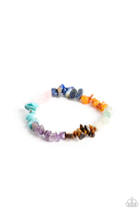 An earthy collection of turquoise, lapis, jade, amethyst, Tiger's eye, orange, gray, and pink pebbles are threaded along a stretchy band around the wrist for a Southwestern finish