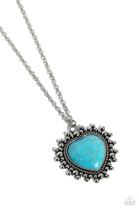 Bordered in a chain-like texture, the center of a studded silver southwestern frame is dotted with an oversized turquoise stone, creating a whimsical medallion at the bottom of a lengthened silver chain. Features an adjustable clasp closure. As the stone elements in this piece are natural, some color variation is normal.