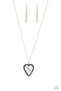 Pressed in the center of a silver chain and studded frame, an oversized, blue marbled stone heart pendant rustically falls down the chest from a classic silver chain. Features an adjustable clasp closure. As the stone elements in this piece are natural, some color variation is norm