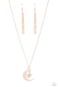 A glassy blue bead is pressed into the center of a three-dimensional rose gold star that dances from the top of a rose gold crescent moon pendant, creating a celestial pendant at the bottom of a dainty rose gold chain. Features an adjustable clasp closure.  Sold as one individual necklace. Includes one pair of matching earrings.