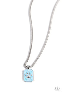 Dangling from a sleek silver snake chain, a rectangular pendant glides down the chest. Featured within the pendant, a silver pawprint, surrounded by light blue pearl paint creates an elegant pet-inspired pendant. Features an adjustable clasp closure.  Sold as one individual necklace. Includes one pair of matching earrings.