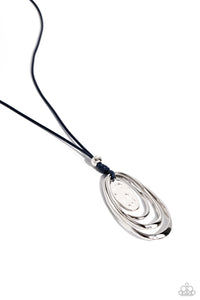 A trio of elongated mismatched warped silver rings swings from the bottom of an elongated blue string, creating an asymmetrically stacked pendant. A hammered silver oval disc swings in the center of the warped rings, adding a dash of tactile texture. Features an adjustable clasp closure.  Sold as one individual necklace. Includes one pair of matching earrings